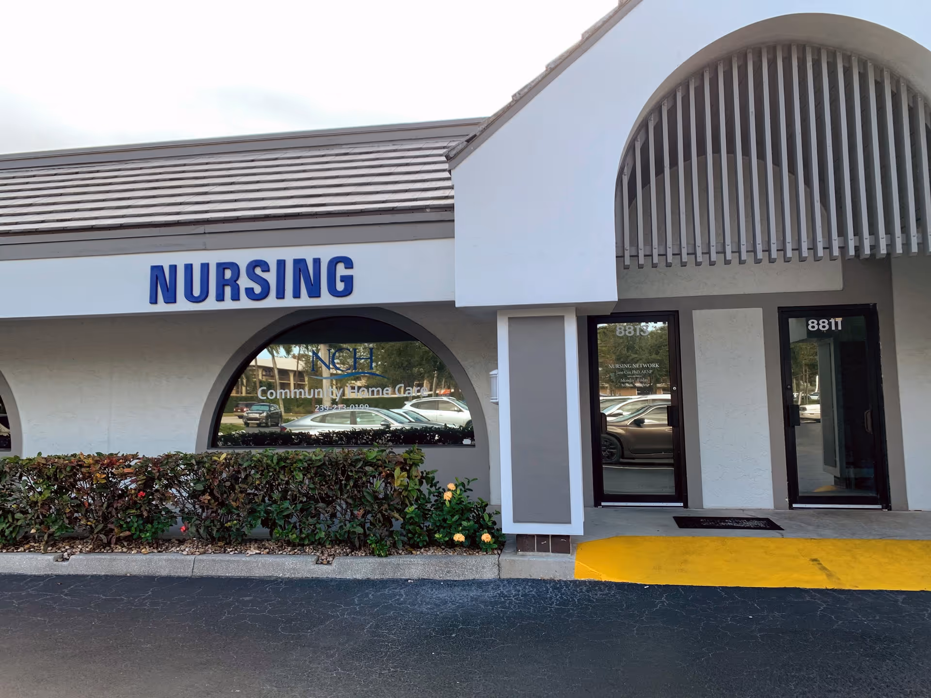 Exterior view of a nursing facility with a blue NURSING sign.