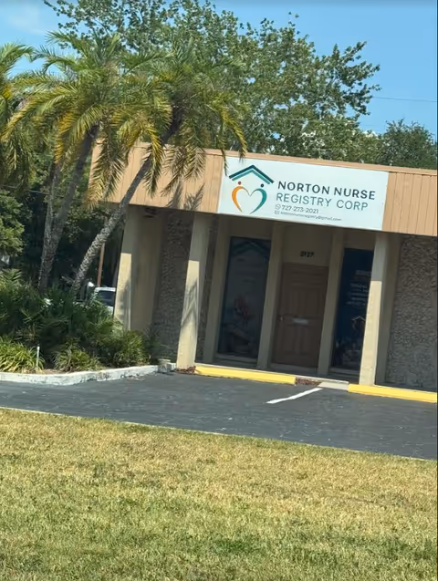 Exterior of Norton Nurse Registry Corp building with palm trees in front.