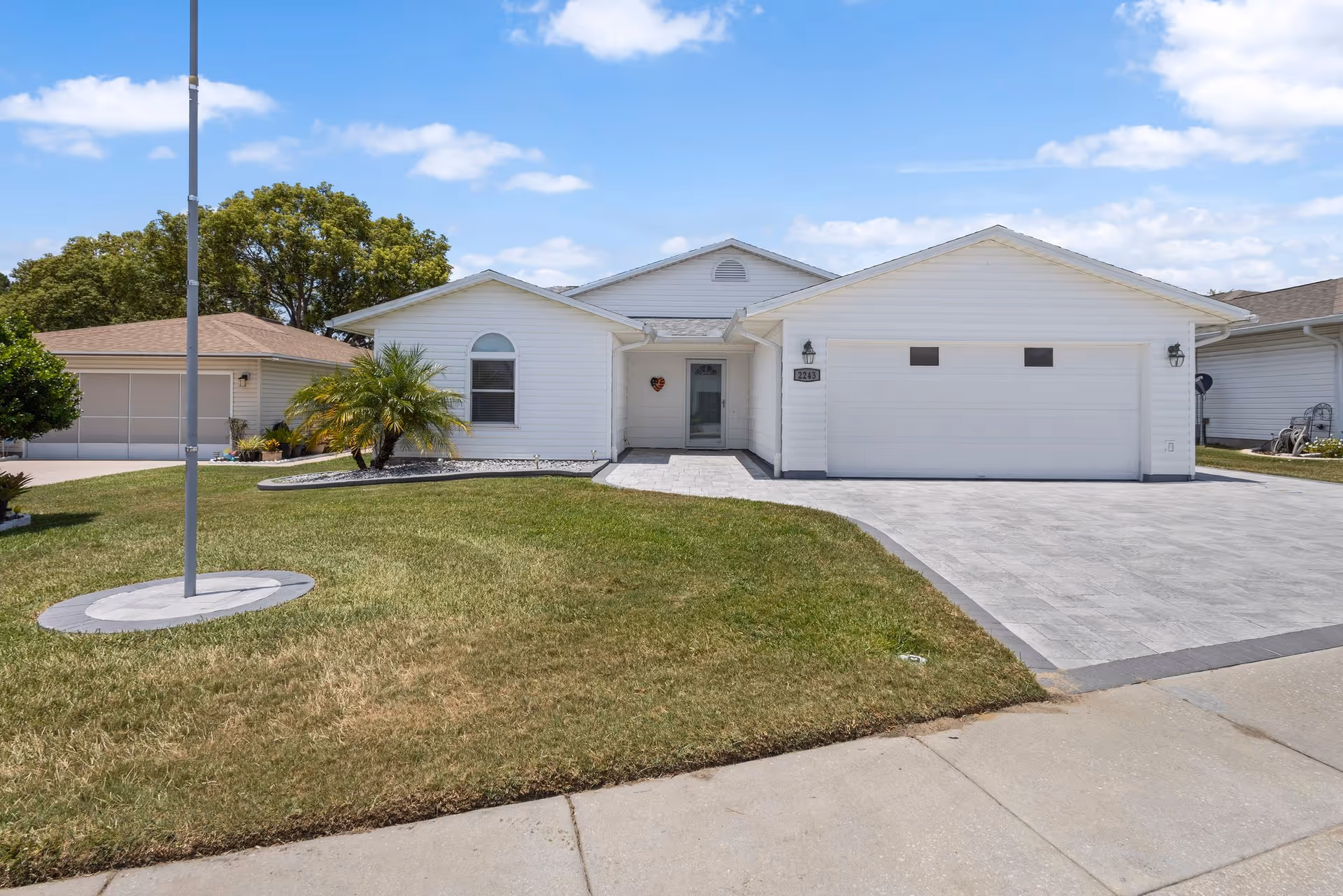White, single-story building with a two-car garage and a paved front driveway.