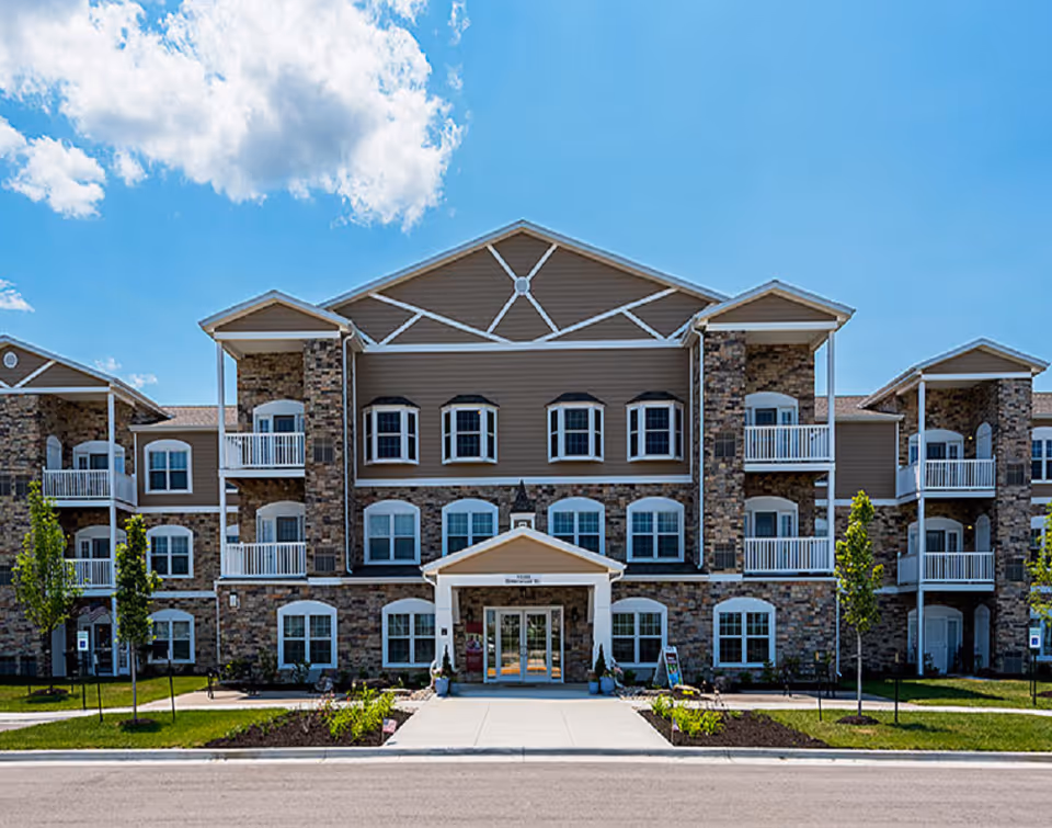 Front view of Connect55+ Olathe senior living building with stone facade and balconies.