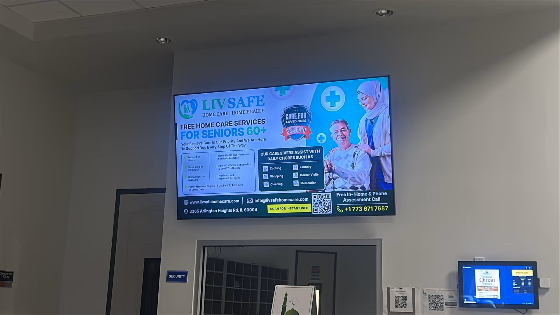 A large digital billboard promoting LivSafe Home Care mounted on a wall inside a facility.