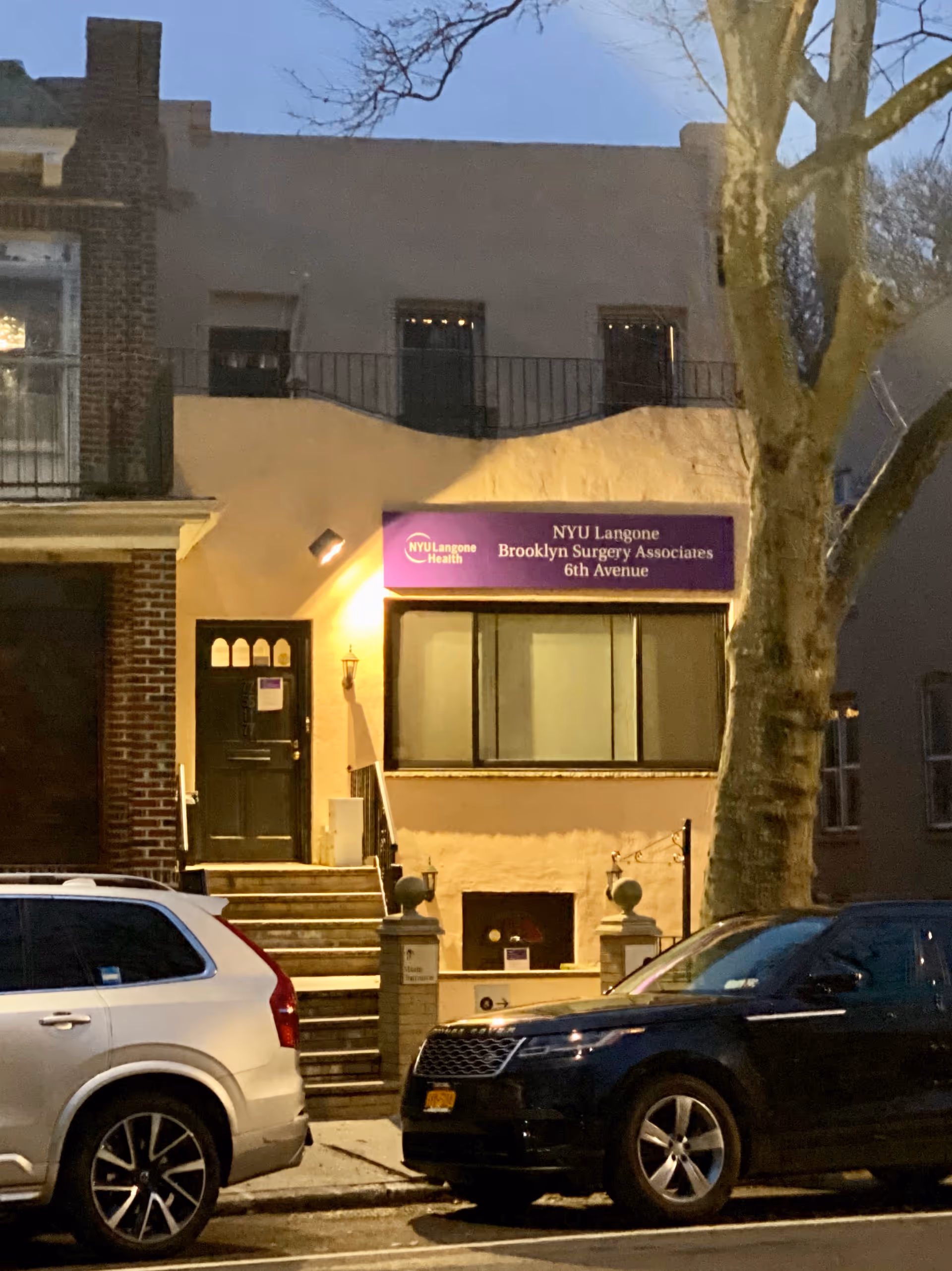 Exterior view of a beige building entrance with purple NYU Langone sign.