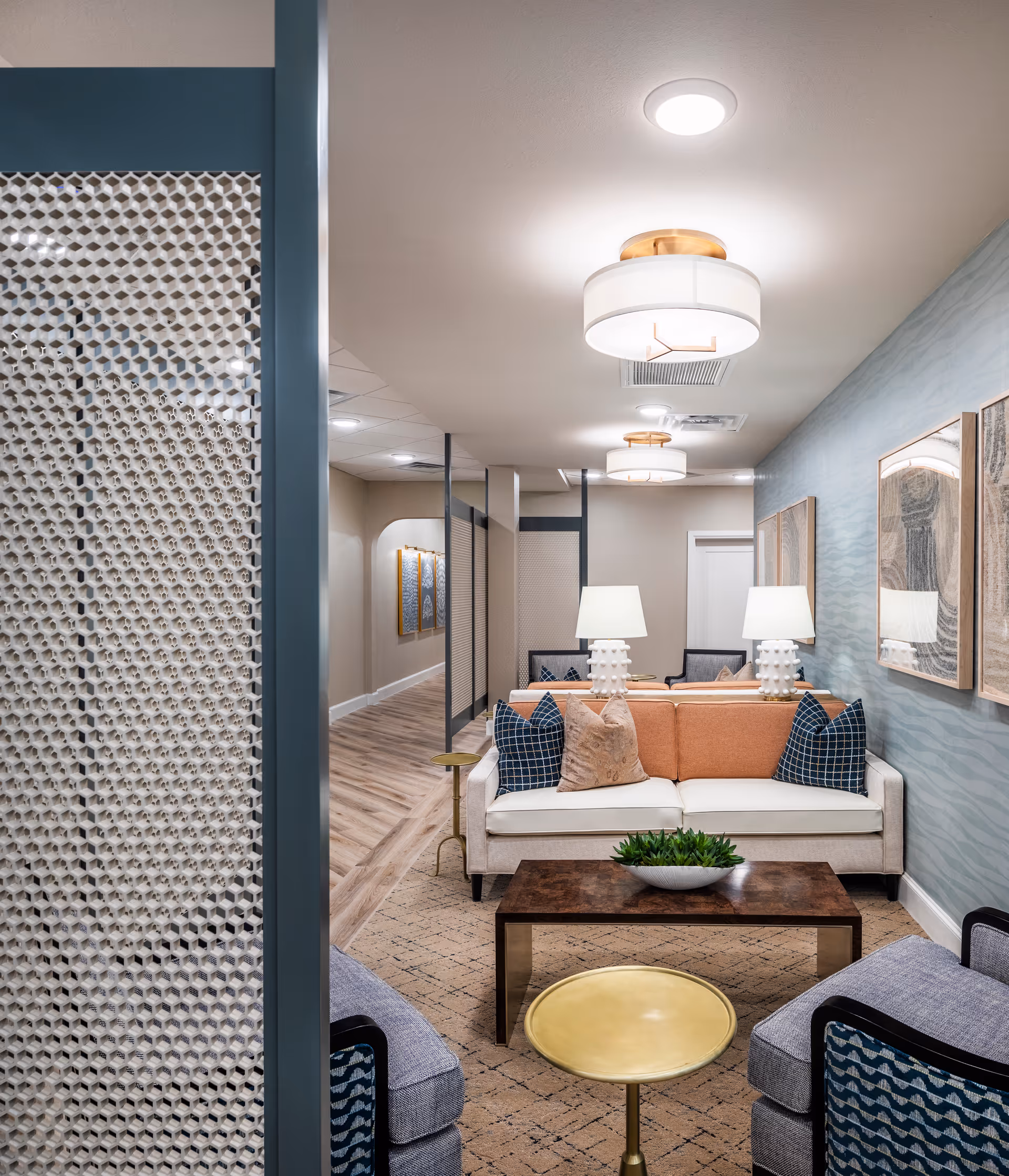 A contemporary interior living room lounge with sofa, coffee table, lamps, and wall art.