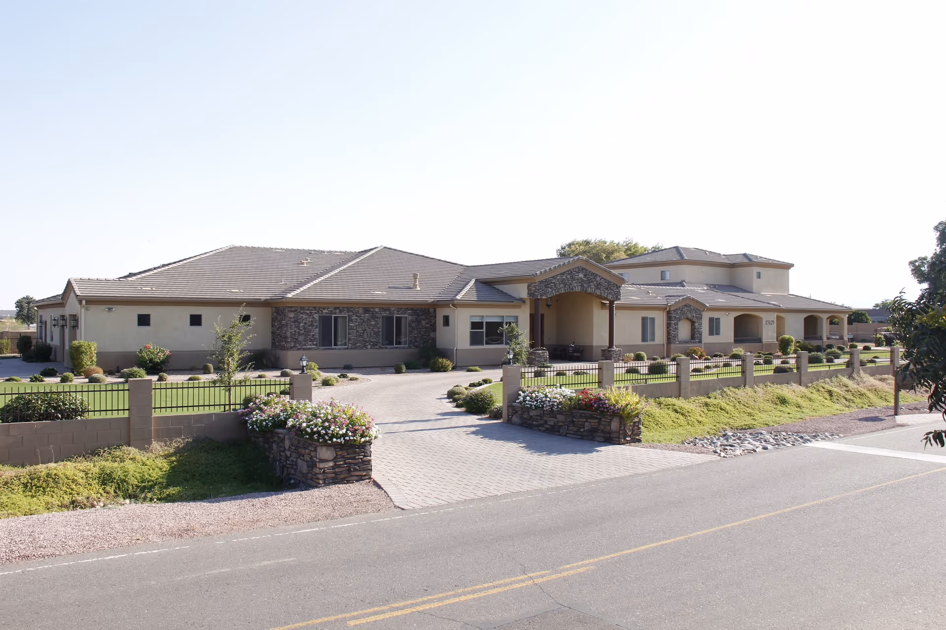 Moonlight Manor senior living facility exterior with a landscaped entrance and gate.