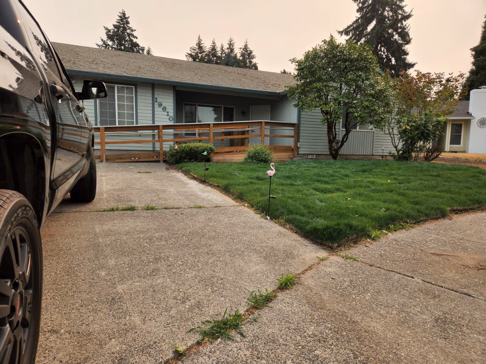 Front view of a single-story facility with a ramp, driveway, and green lawn.