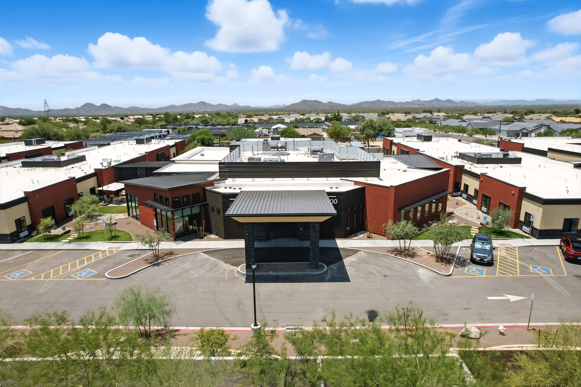 Aerial view of Cave Creek Assisted Living front, with central entrance and surrounding parking.