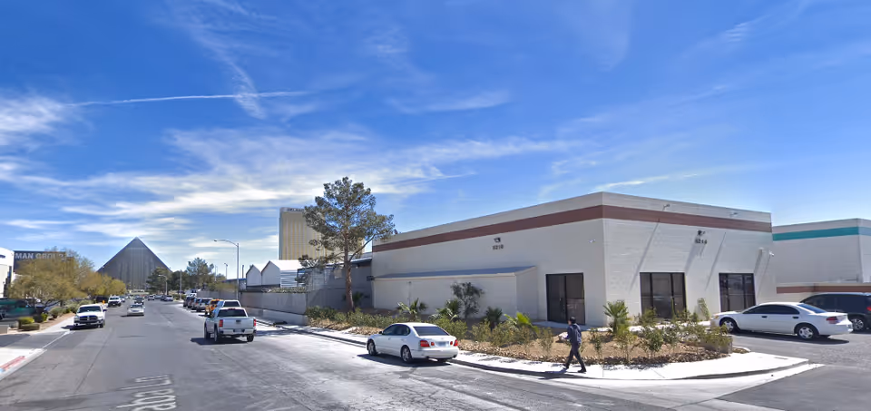 Sunny street view of Ashby Home Health Nevada building exterior with parked cars