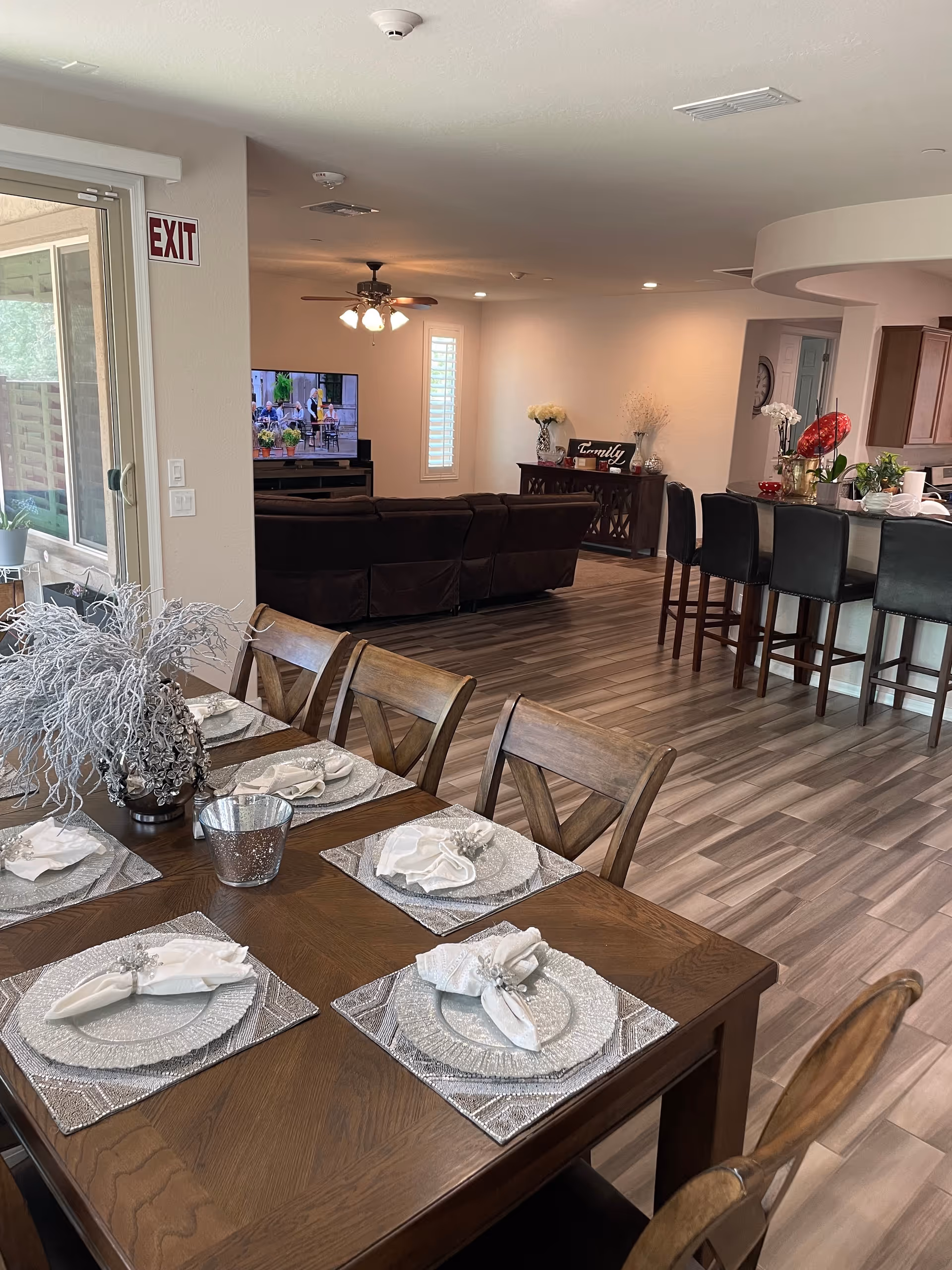 Open dining and living area with a table set for a meal and a TV lounge.
