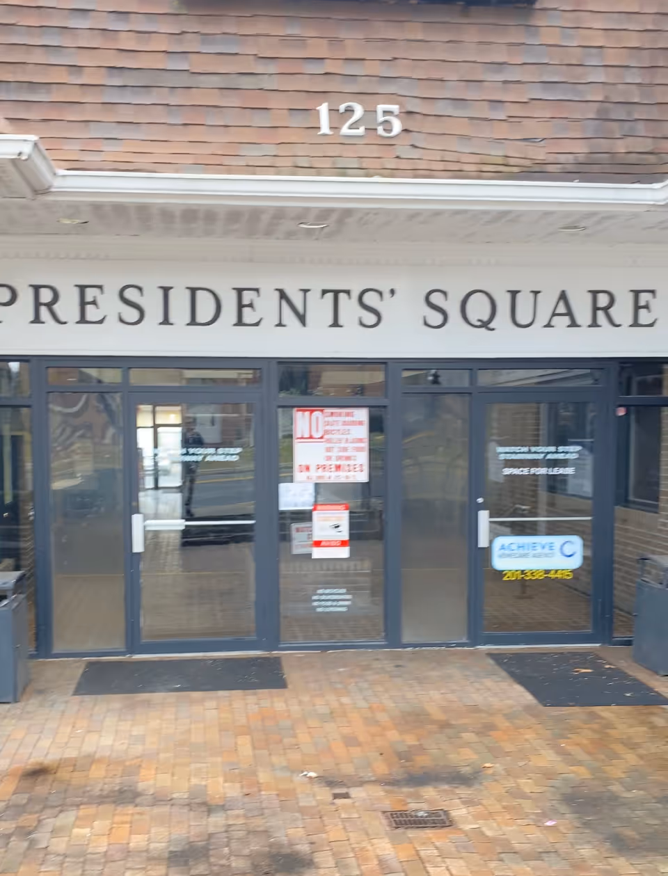 Exterior building front with glass doors and Presidents' Square signage.