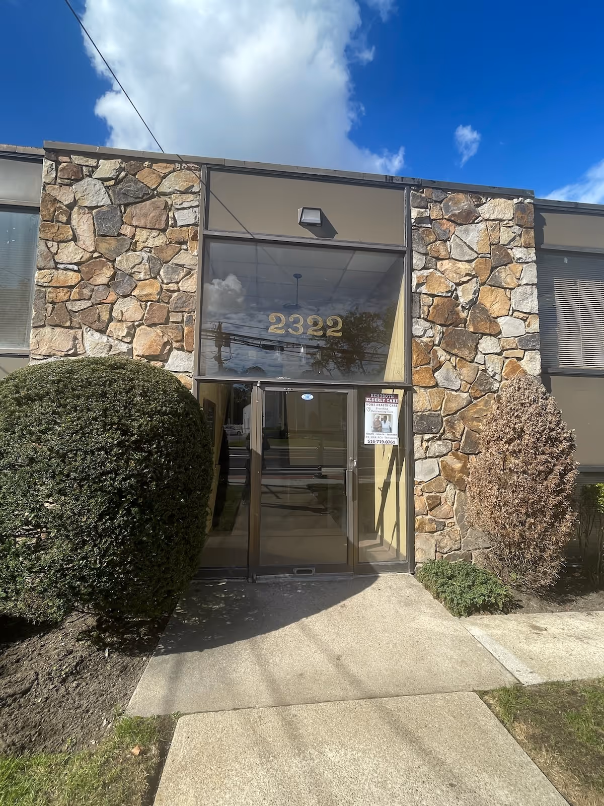 Stone-facade entrance to a senior care facility with glass doors and 2322 address