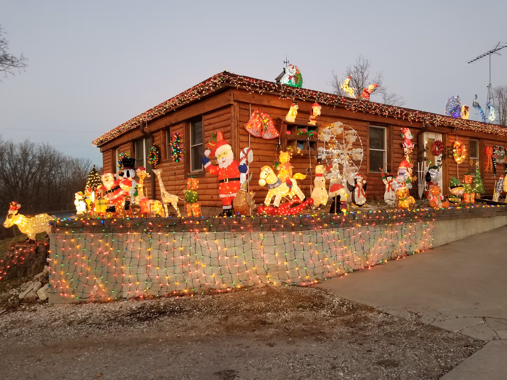 A wooden care center building decorated with colorful Christmas lights and holiday figures.