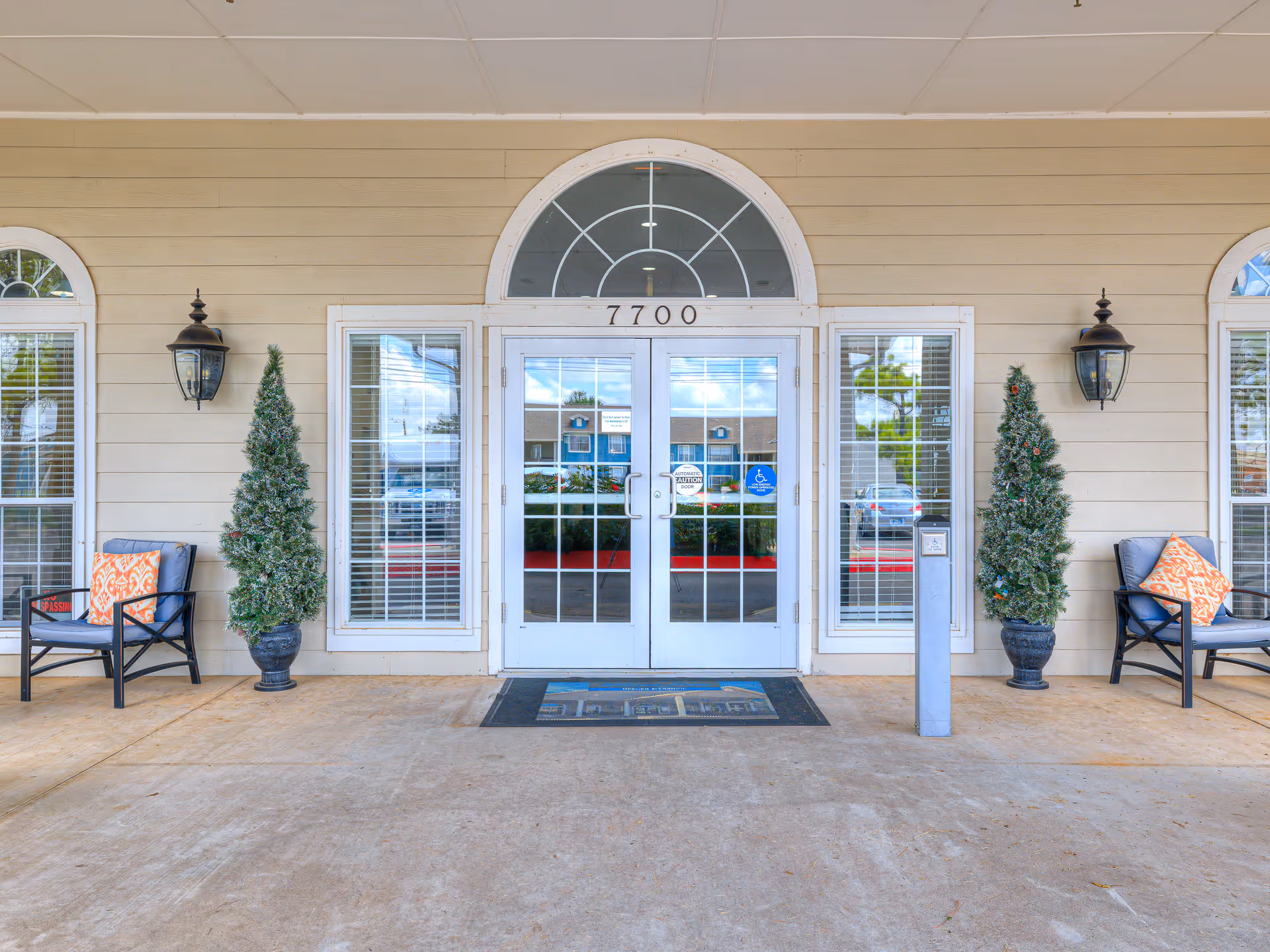 Exterior entrance of Hefner Mansions Senior Independent Living with glass doors, planters, and seating.