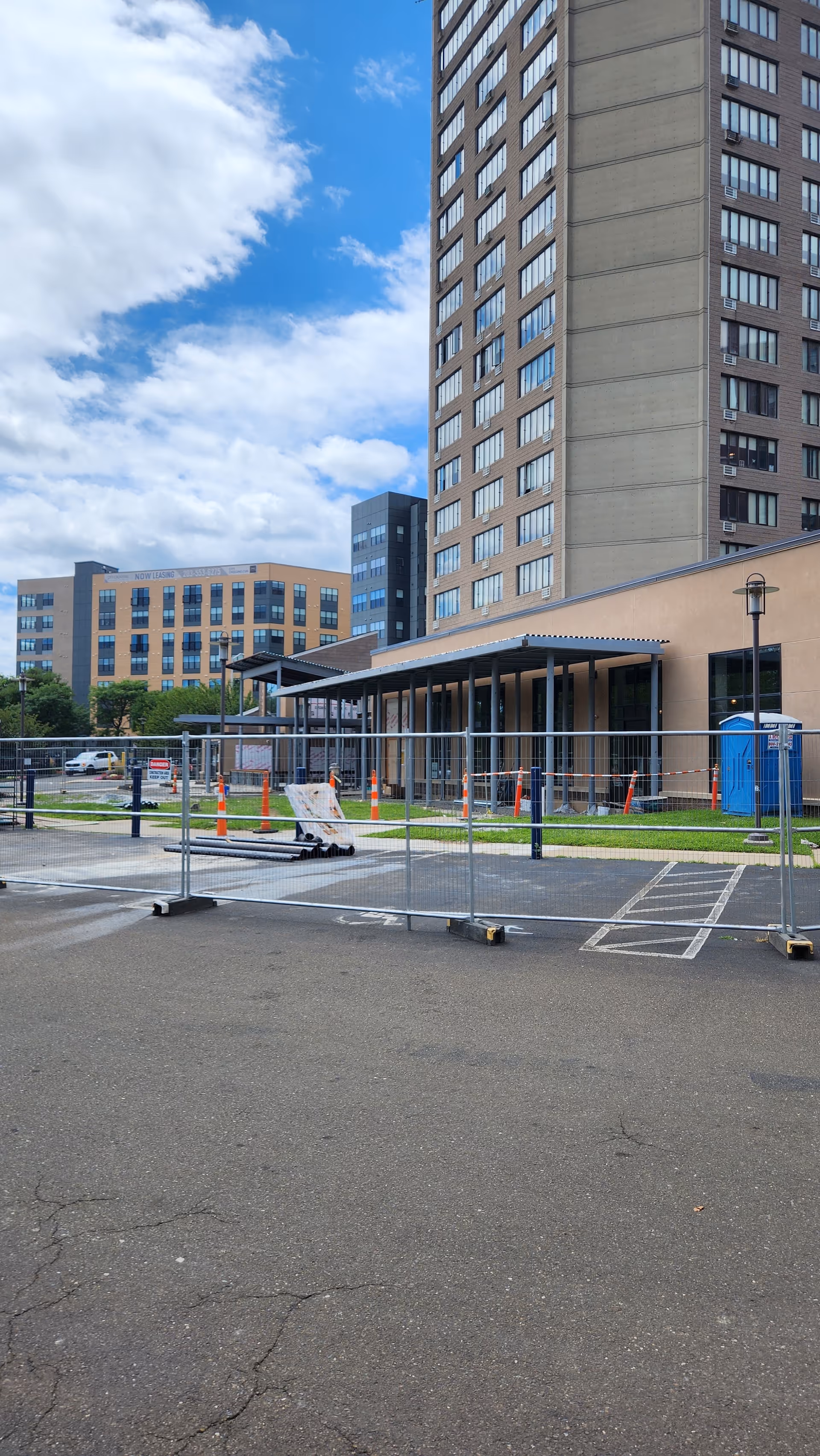 Exterior view of The Towers at Tower Lane with fencing and portable toilets.