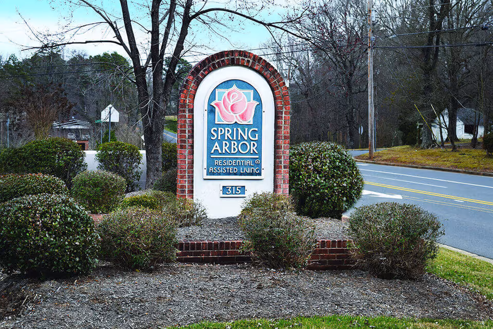 Spring Arbor Residential Assisted Living sign at a landscaped entrance along the road