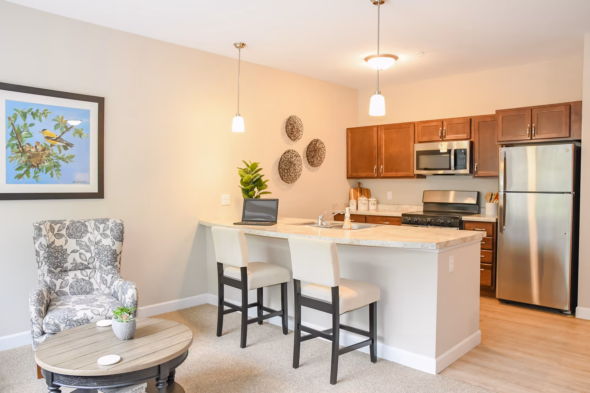 Open kitchen with island, bar stools, and living area seating with wall art.