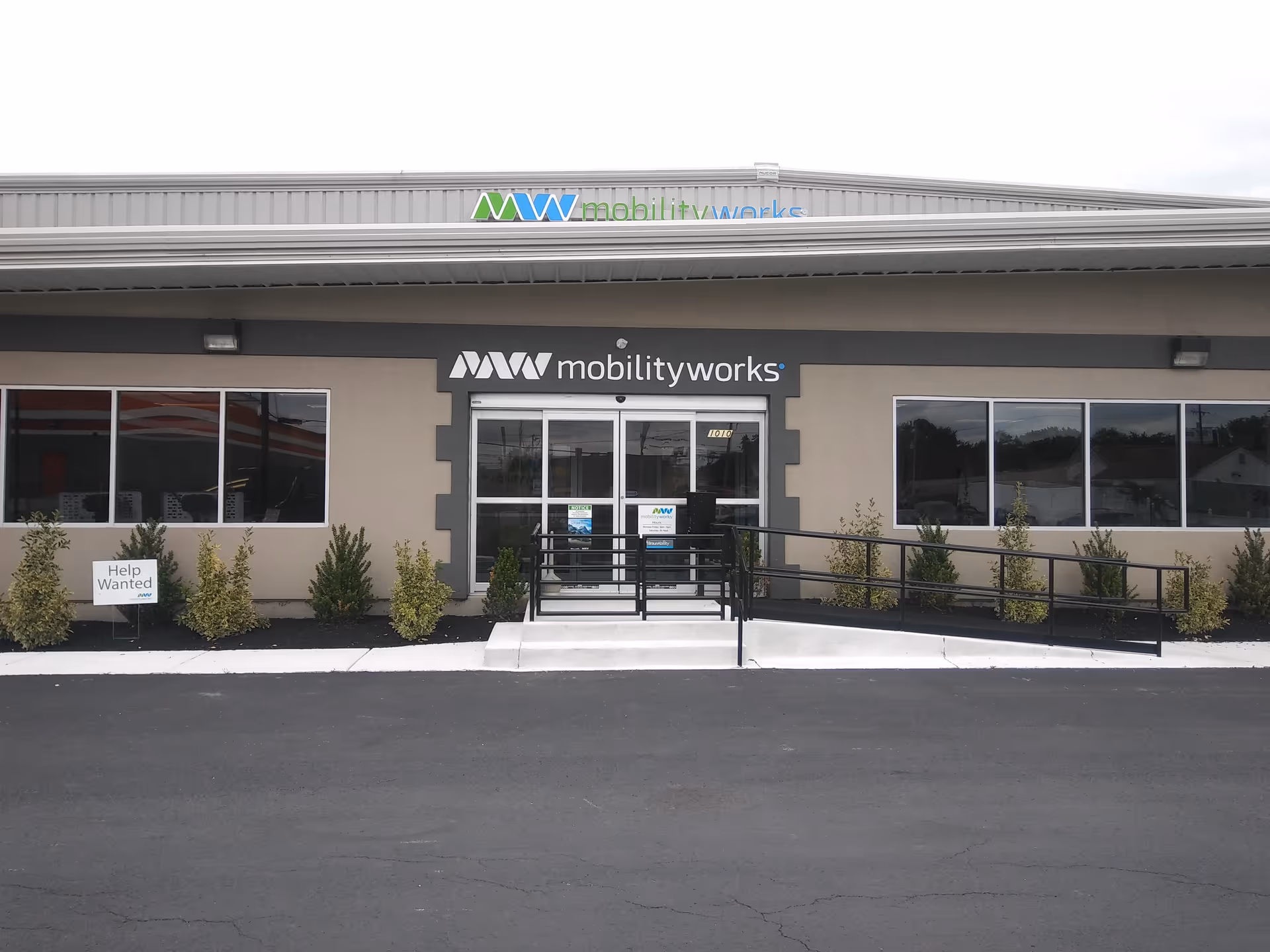 Exterior view of a MobilityWorks building with glass entrance and wheelchair ramps.