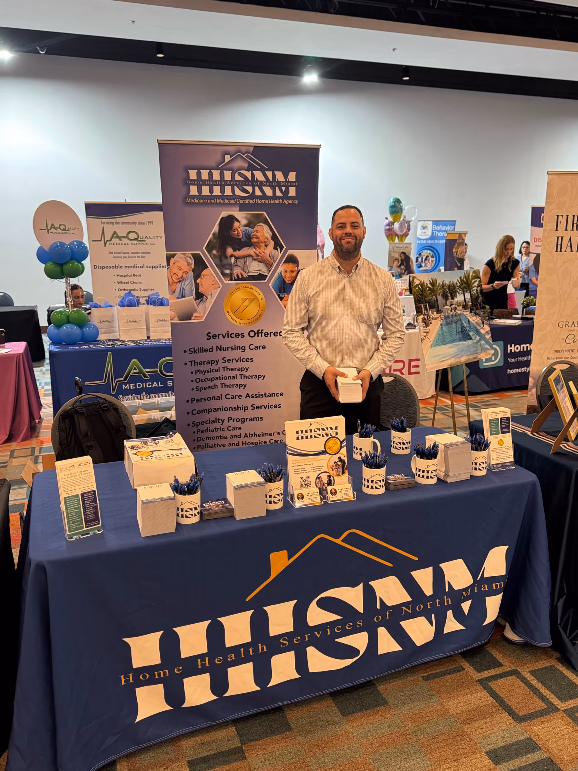 Man stands at Home Health Services of North Miami booth at a healthcare expo.