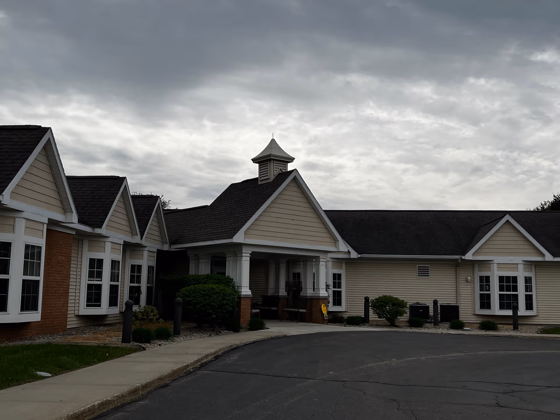 Front exterior of Devonshire Retirement Village with peaked roofs and a covered entrance.