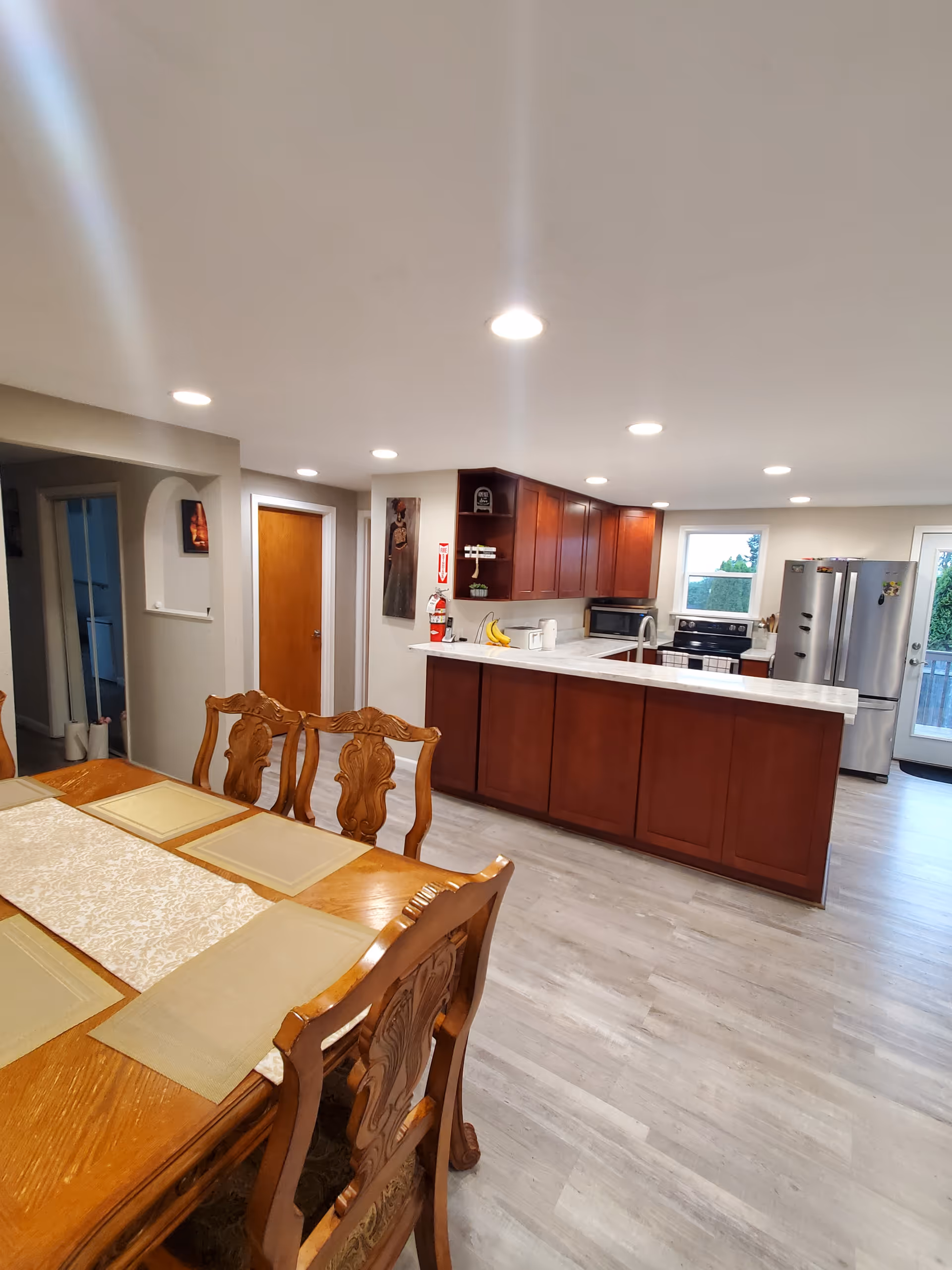 Open-concept dining area with a wooden table and a long kitchen island.