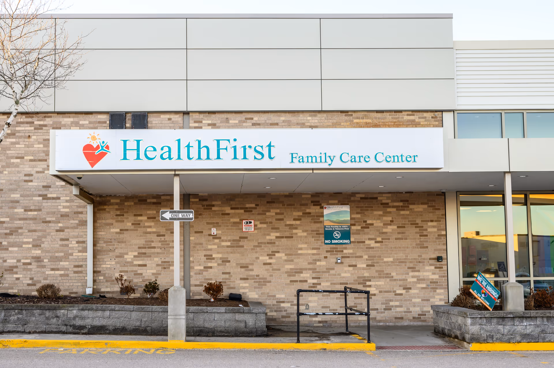 Front view of a brick health care center with a large HealthFirst Family Care Center sign.
