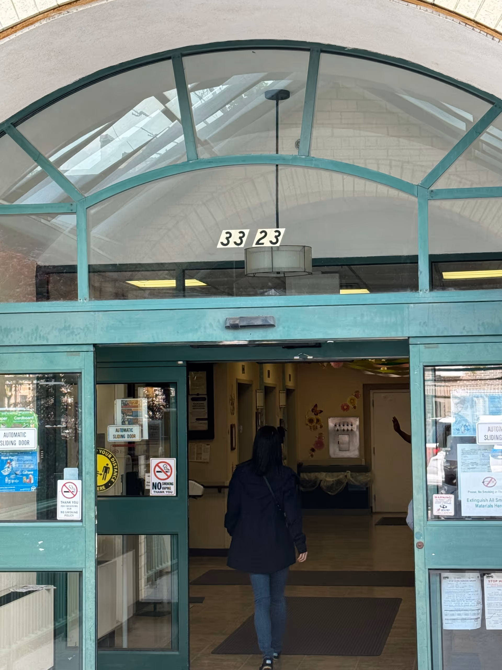Teal-framed glass entrance of Union Plaza Care Center with a person walking inside.