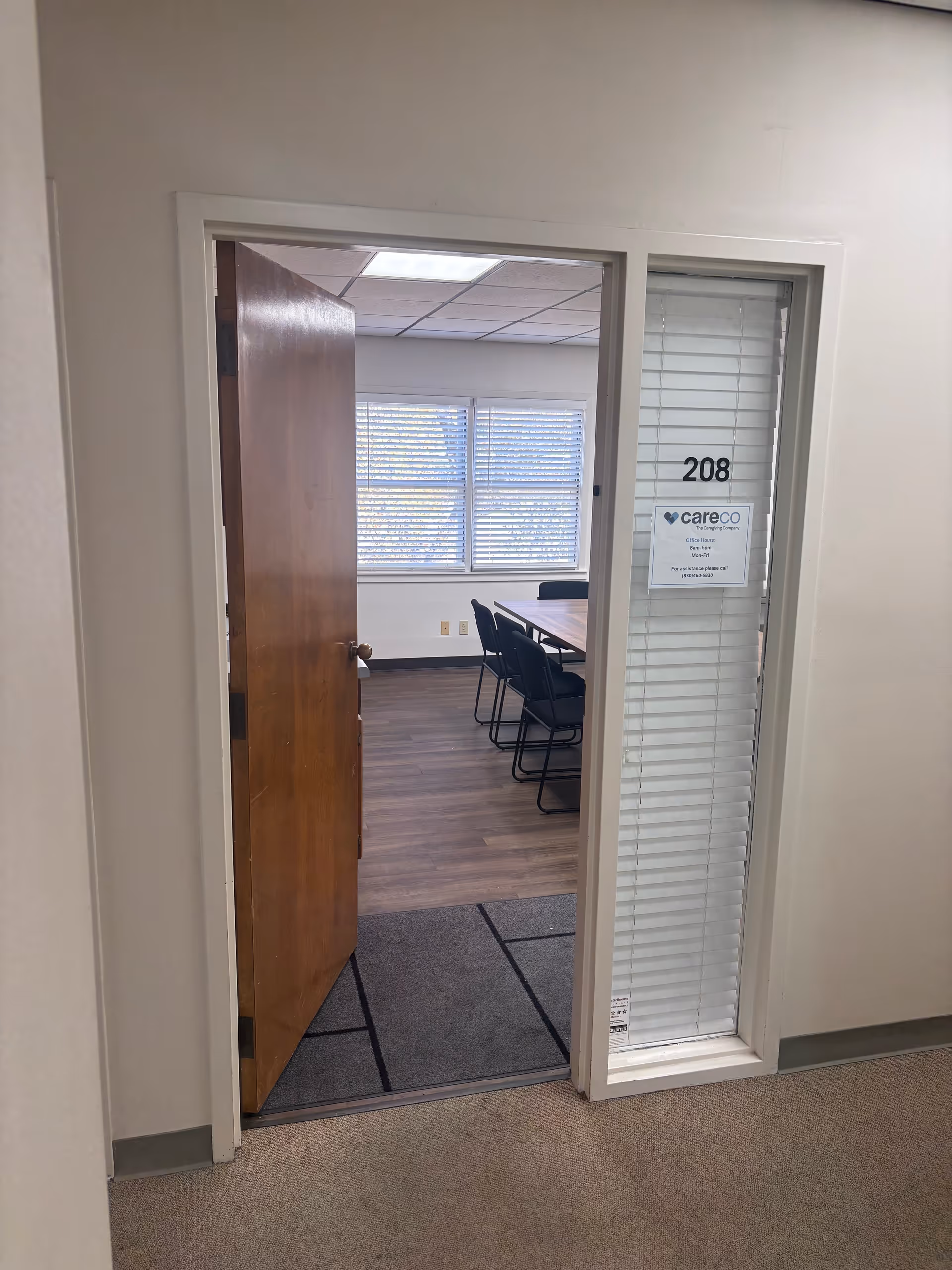 Open doorway reveals a conference room with a table and chairs inside.