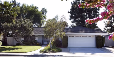 Front view of a single-story facility with a two-car garage and manicured front yard.