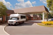 Front of Life Care Center of Wilbraham with a covered driveway and parked shuttle bus.