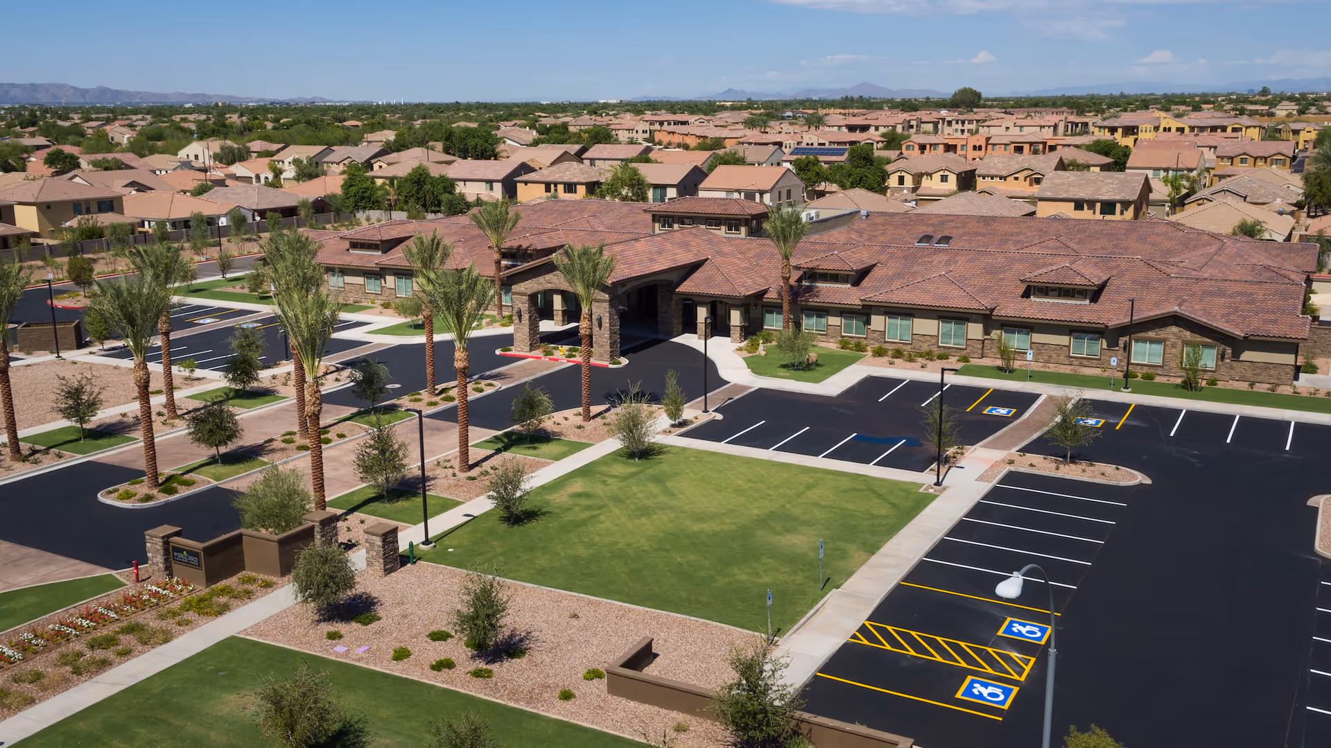 Aerial view of Seasons Living senior campus with beige buildings and parking.