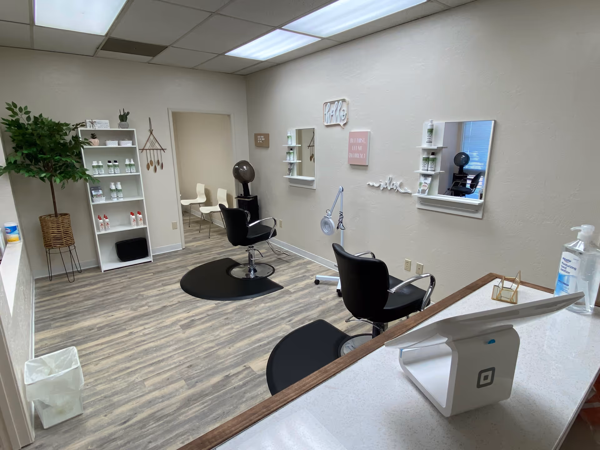 A modern hair salon area with chairs, mirrors, shelves of products in a senior living facility.