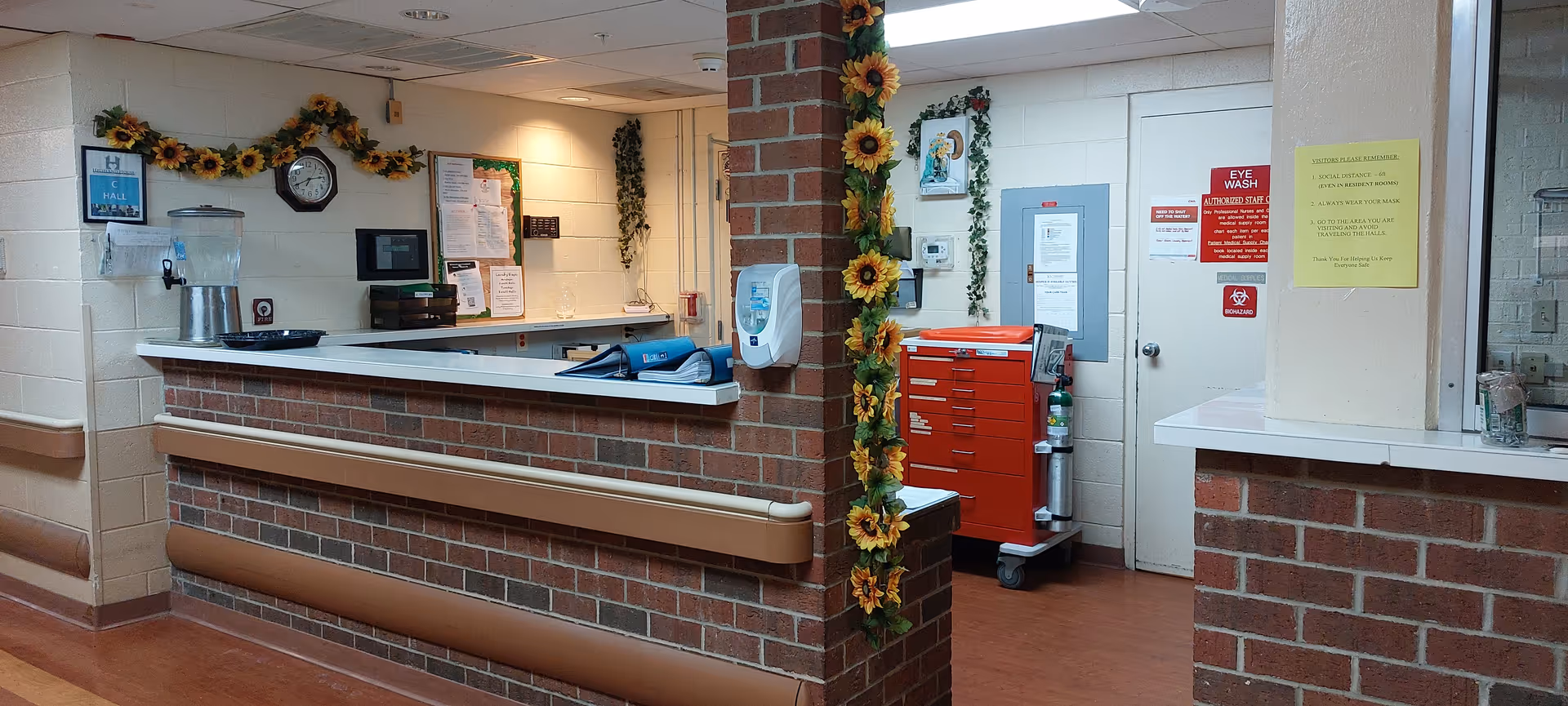 Reception desk in Highland House facility with brick counter and sunflower garlands.