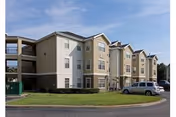 Exterior view of Endwell Homes senior living building with parked cars on a sunny day.