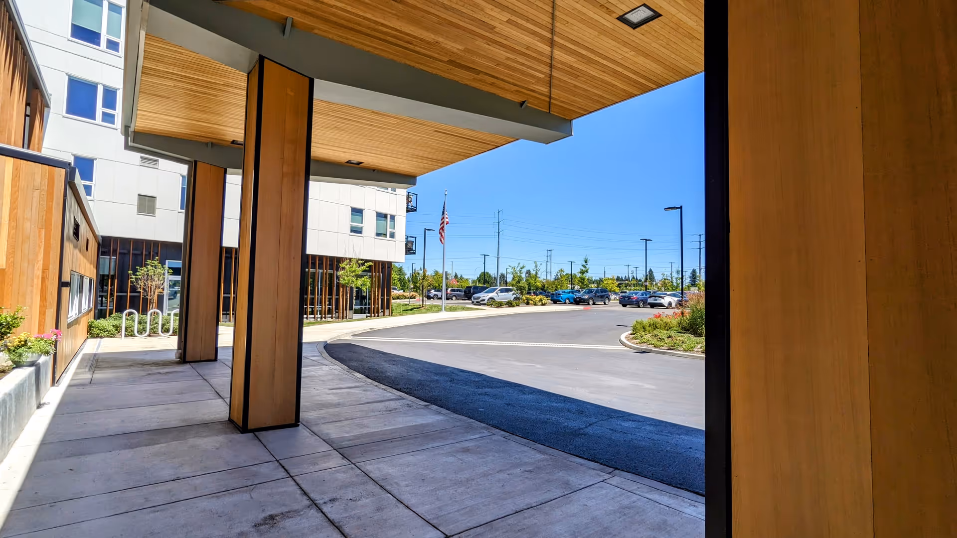Exterior covered walkway at The Ackerly at Reed’s Crossing with adjacent parking.