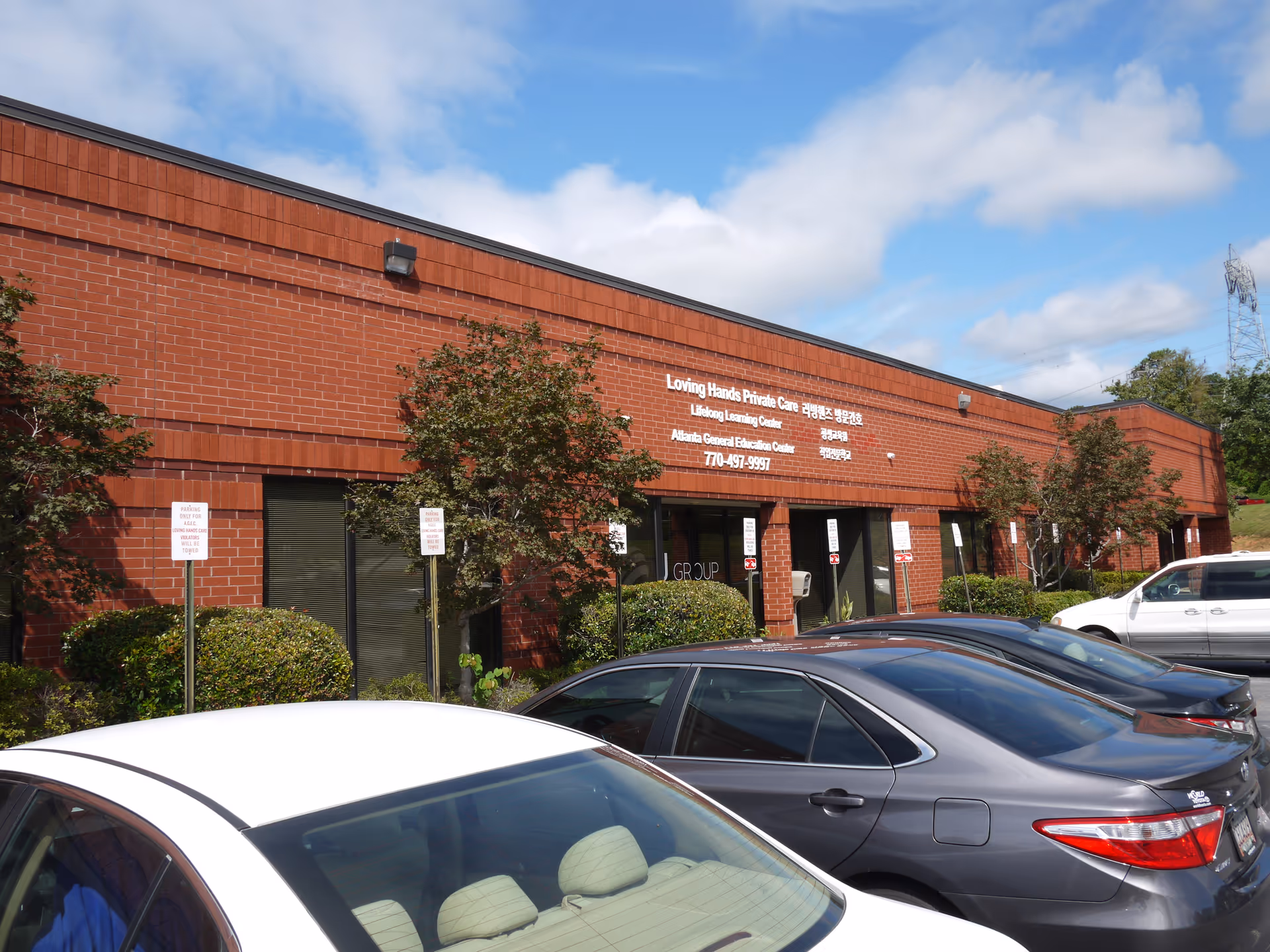 Exterior view of Loving Hands Private Care facility with parked cars in front.