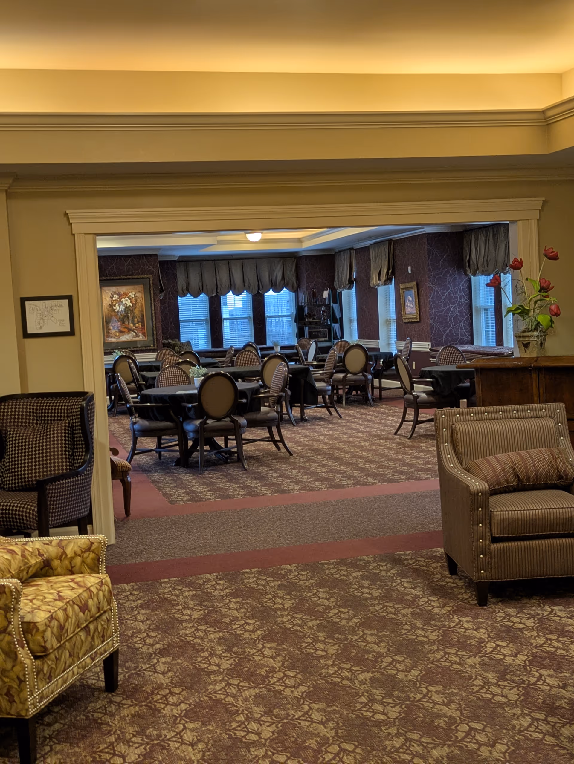 Cozy lounge area opens to a formal dining room with round tables.