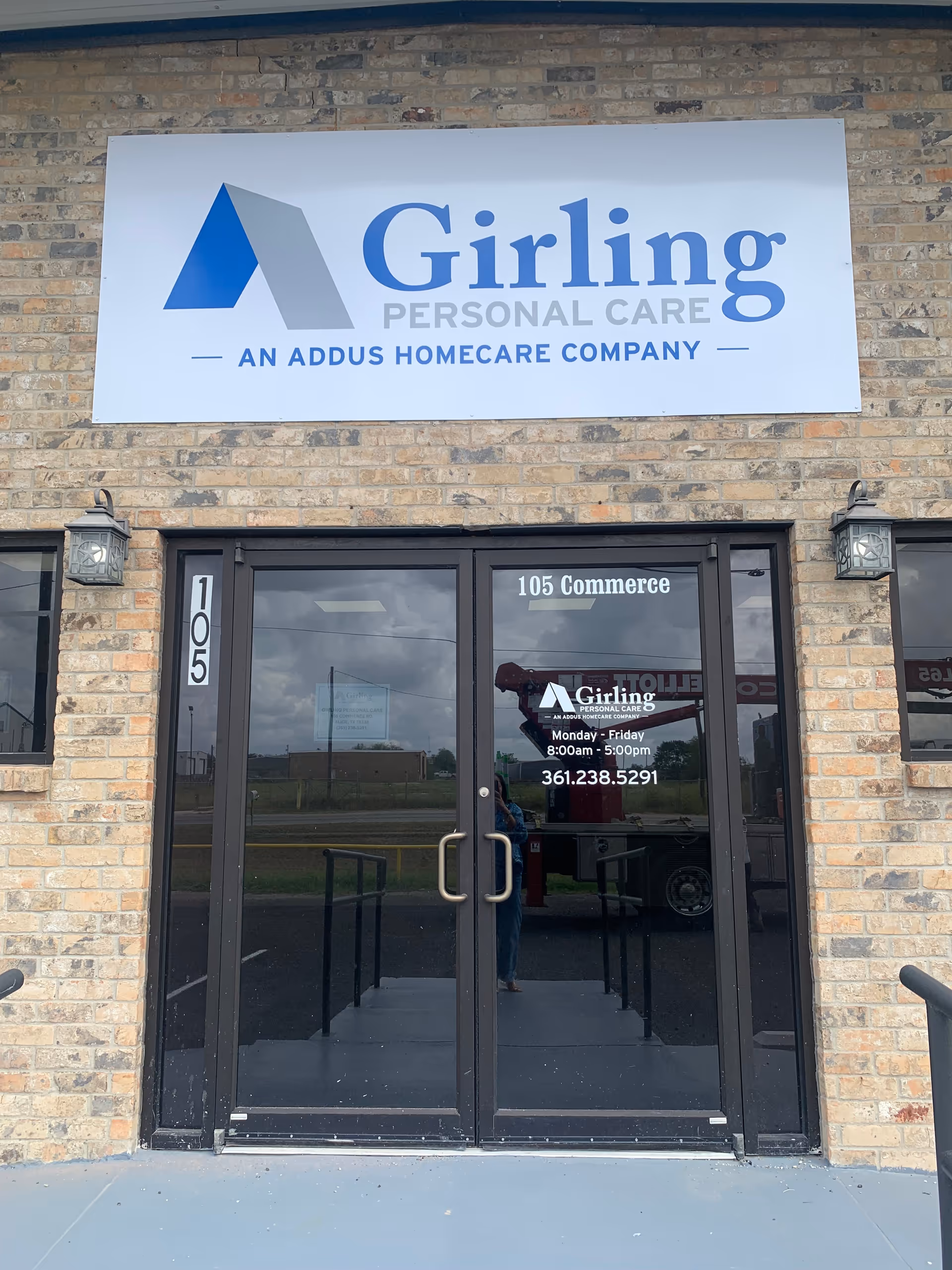 Exterior brick building entrance featuring a Girling Personal Care sign above glass doors.