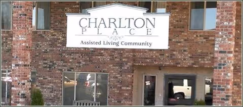 Brick building exterior with Charlton Place sign and entrance door.