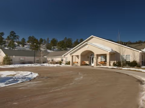 Exterior view of Lark Springs facility with circular driveway, entrance arch, and snow.