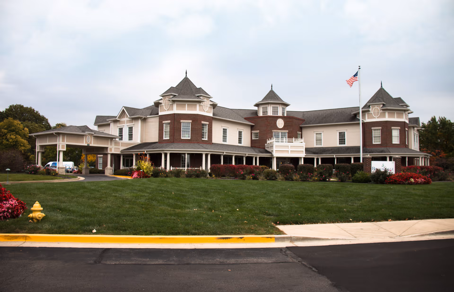Brookdale Carmel senior living facility exterior with manicured lawn and American flag in front