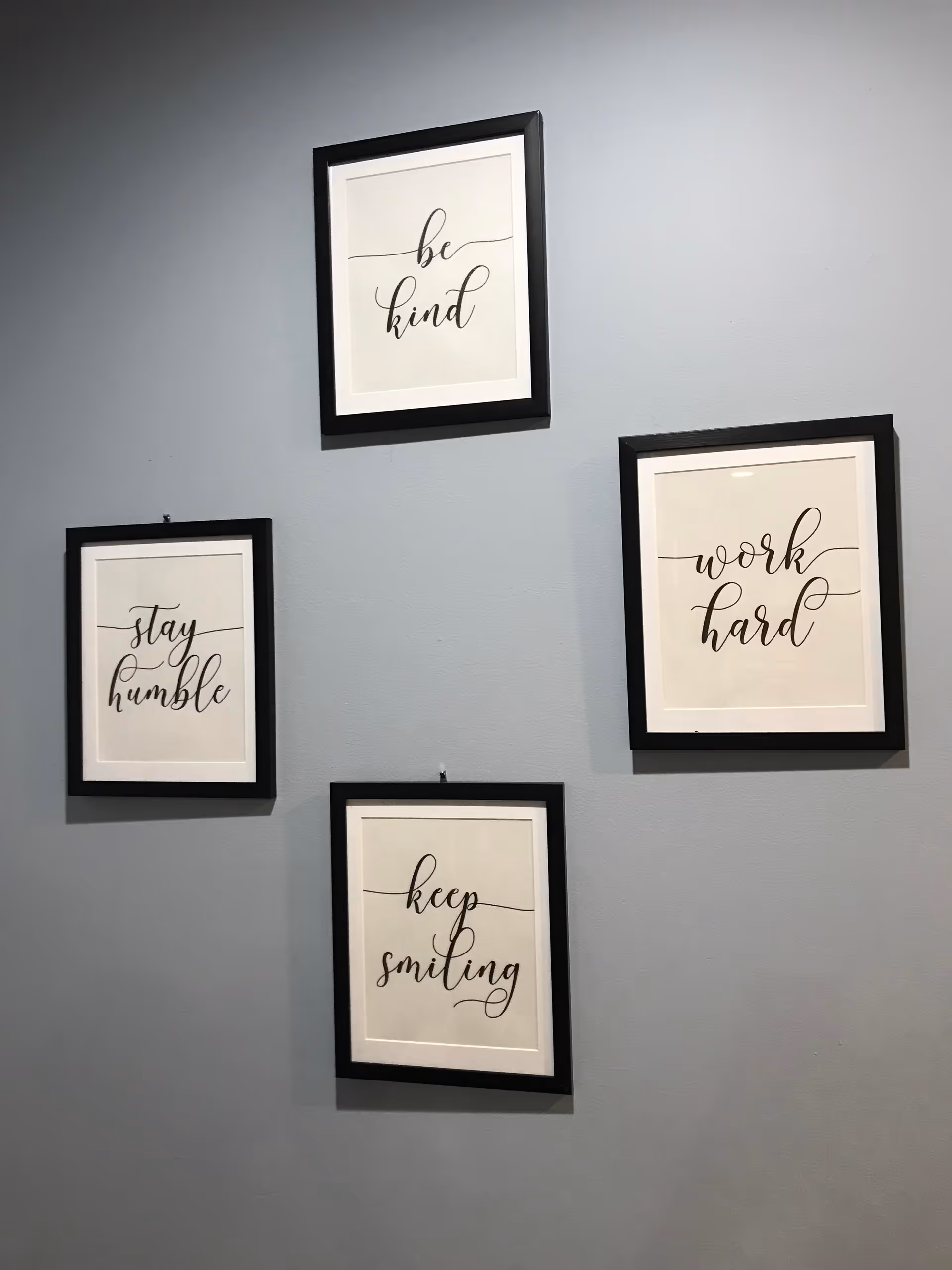 Four framed inspirational quotes hung on a blue interior wall.