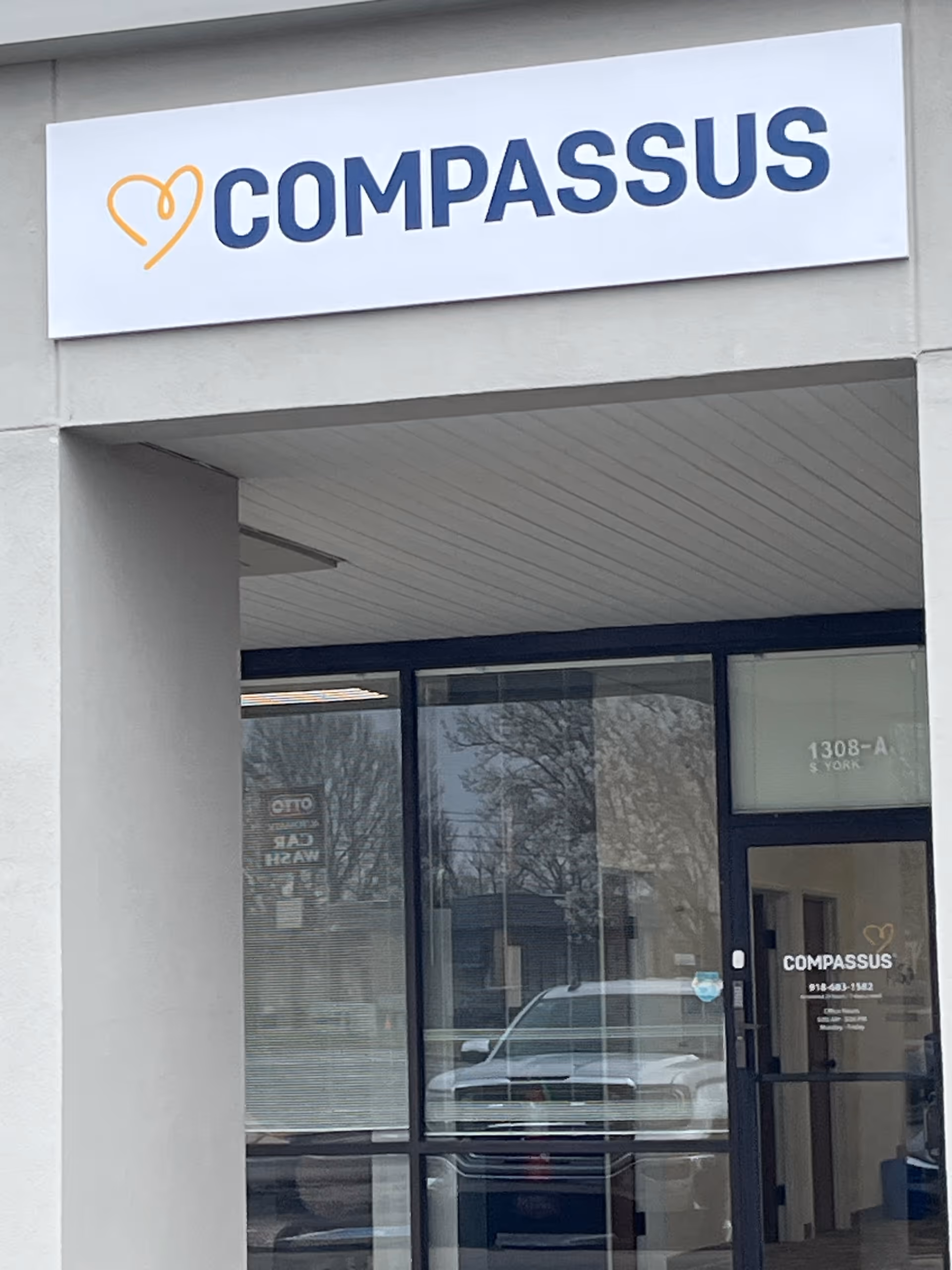 Exterior view of a Compassus facility entrance with a large sign.