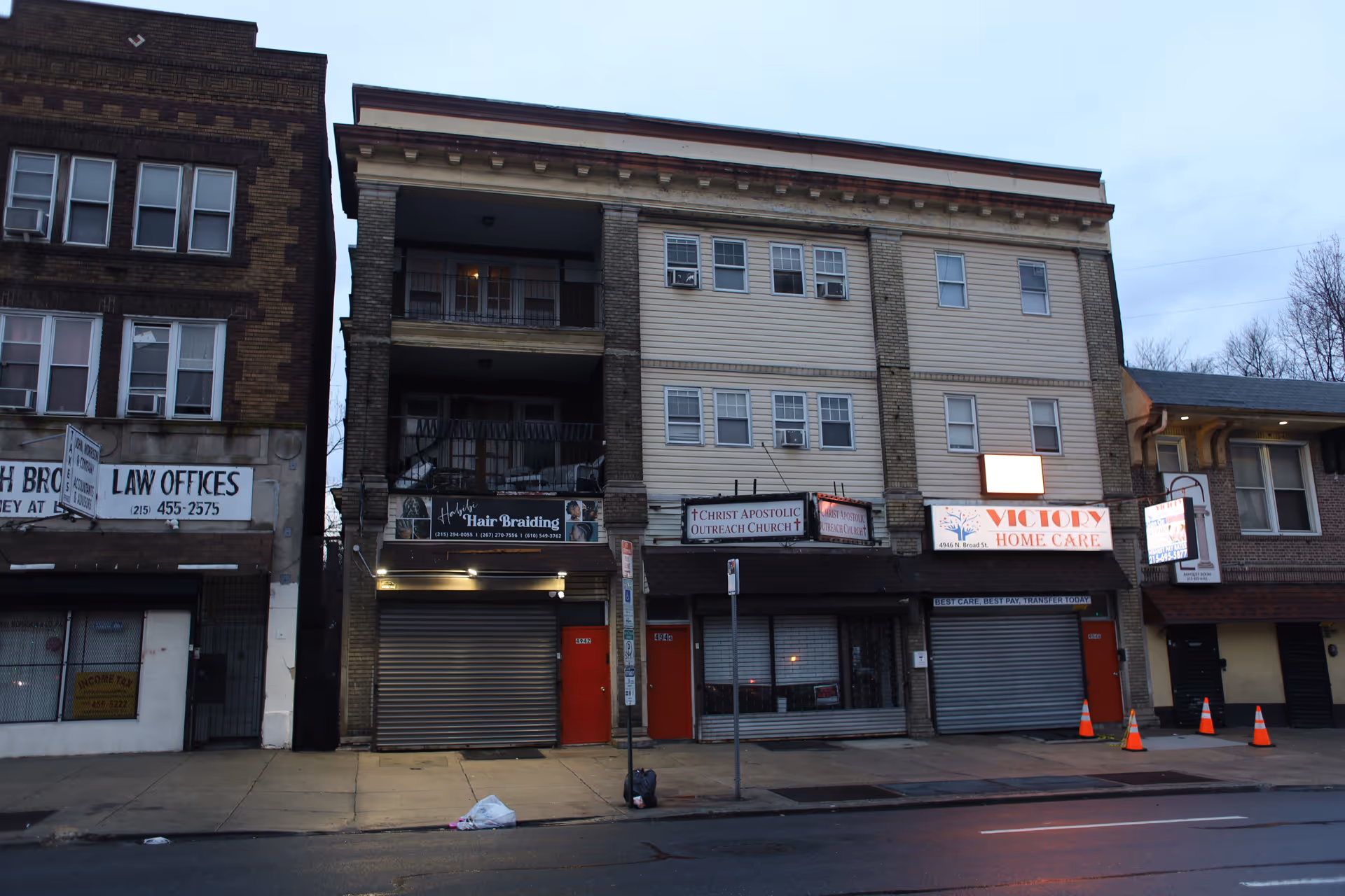 Row of storefronts on a city street with a Victory Home Care sign.