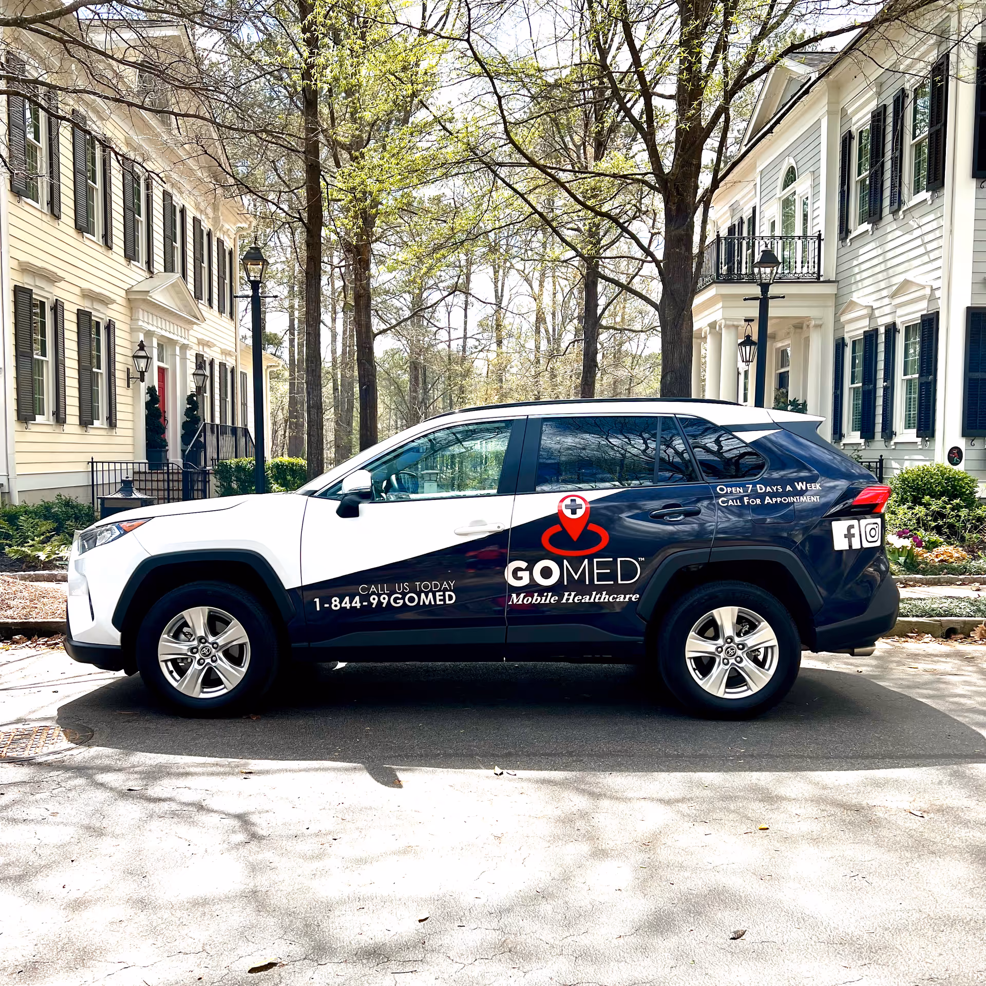 GOMED Mobile Urgent Care vehicle parked on a residential street in front of townhomes.