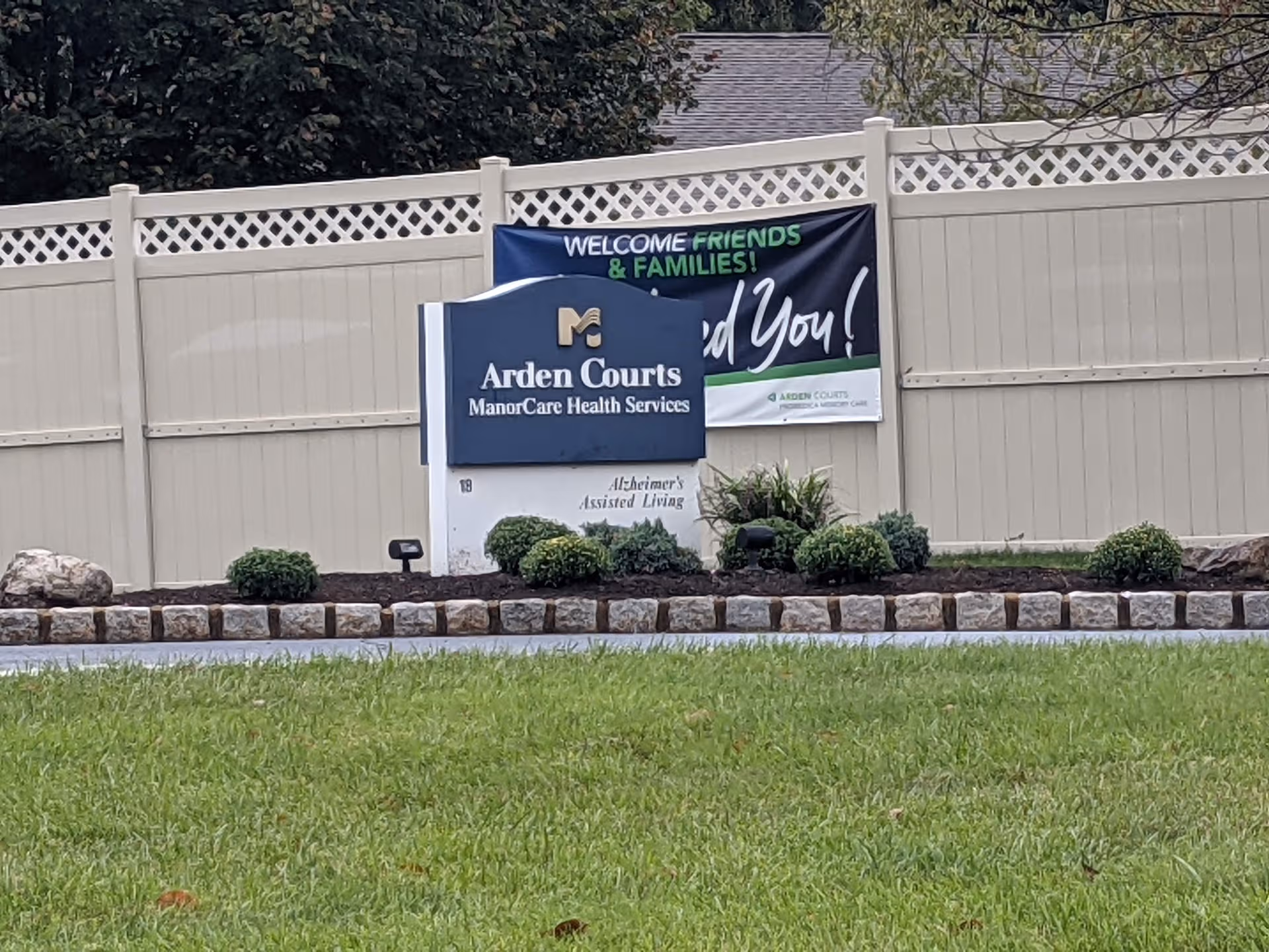 Exterior view of Arden Courts sign with welcome banner, shrubs, and landscaped front yard.
