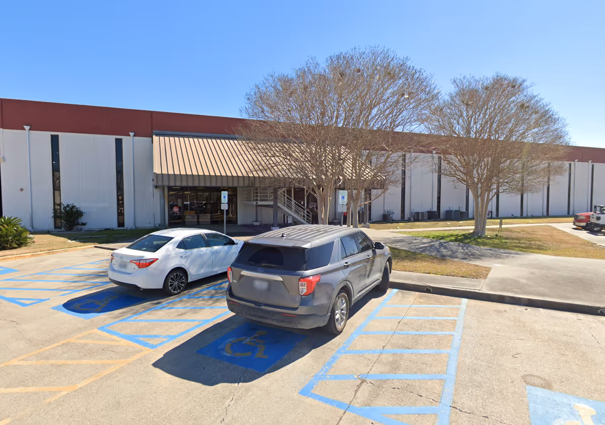 Exterior view of a Legacy Home Health Agency building with a parking lot and trees.