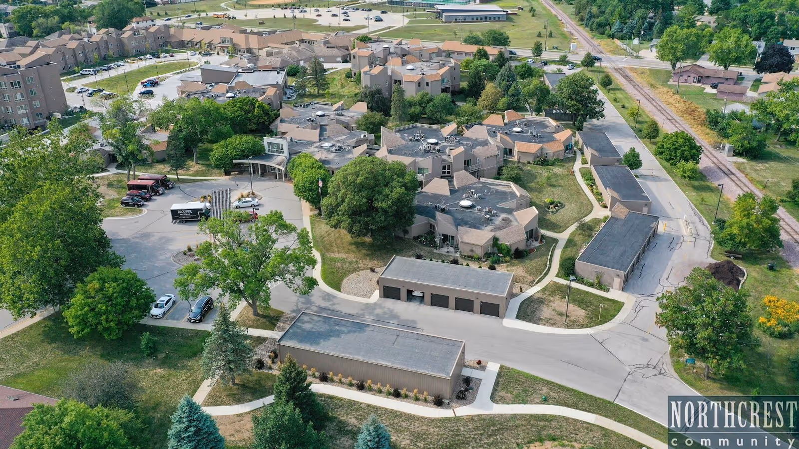 Aerial view of a senior living campus with connected buildings and green trees.