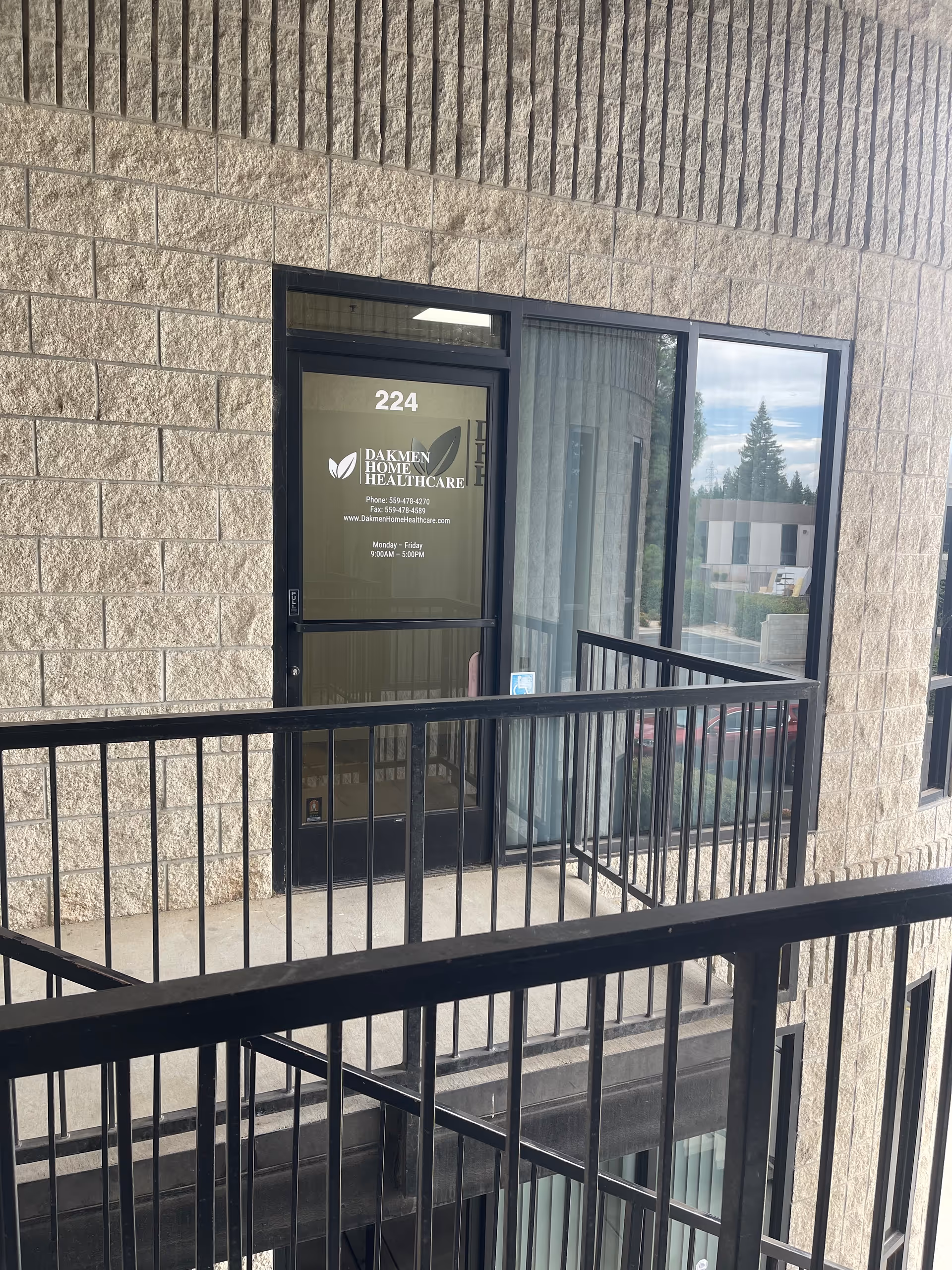 Exterior view of Dakmen Home Healthcare entrance with glass door and railing.