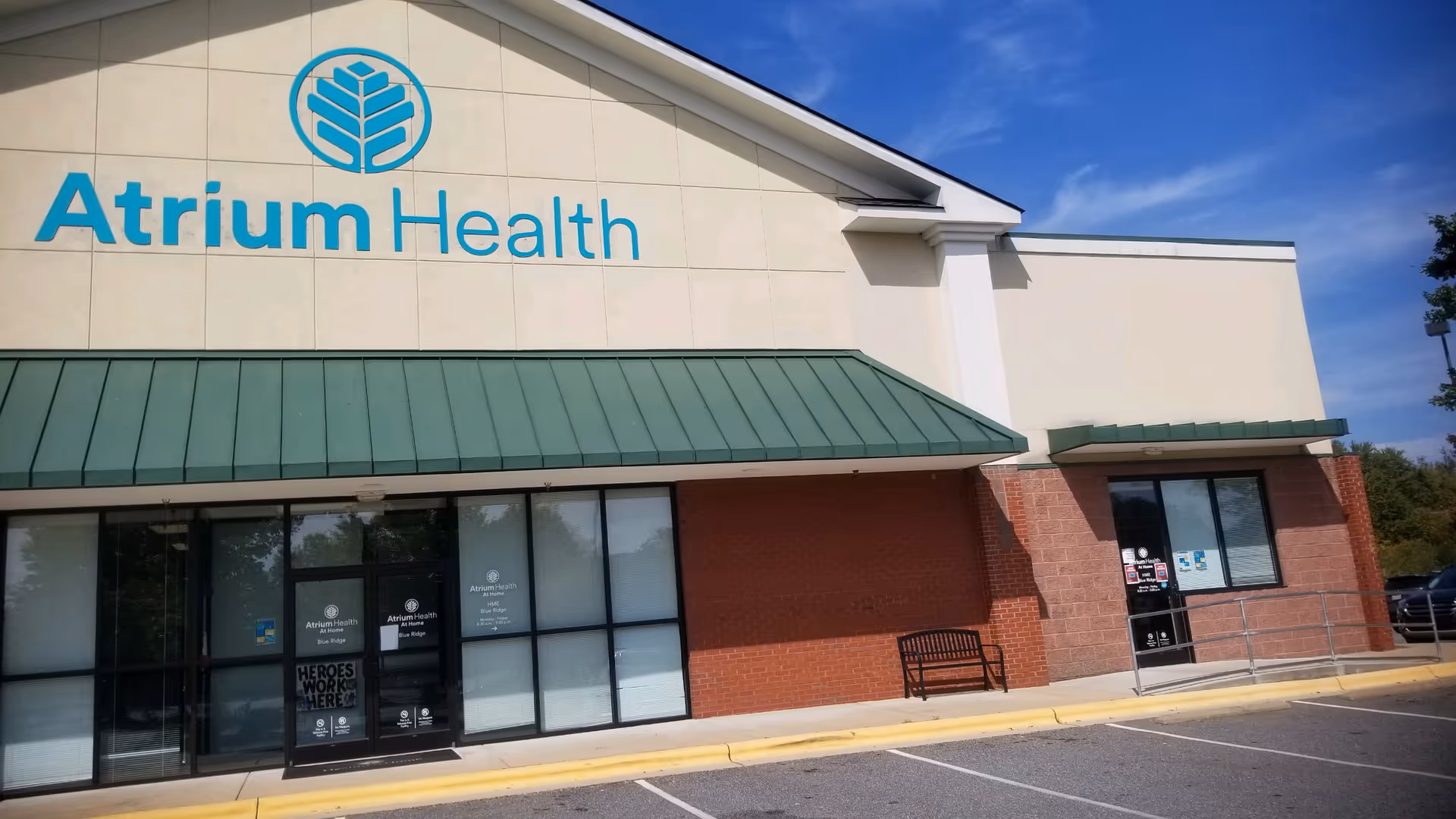 Exterior view of Atrium Health At Home building with teal logo and signage.