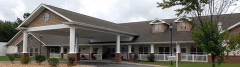 Long, single-story senior living facility with a covered entrance and landscaped front yard.