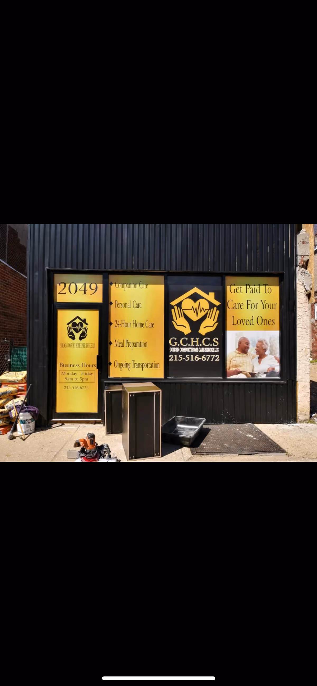 Storefront with yellow signs advertising Golden Comfort Home Care Services on a black facade.